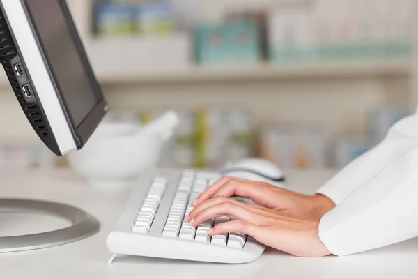 Mãos farmacêuticas digitando no teclado do computador — Fotografia de Stock