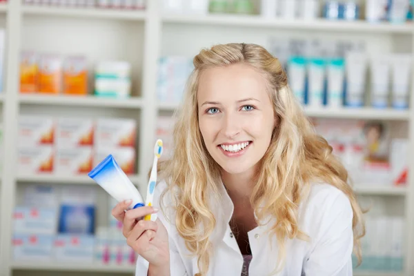 Farmacéutica femenina con pasta de dientes y cepillo de dientes —  Fotos de Stock