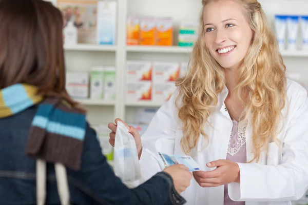 Farmacéutica femenina que recibe dinero del cliente por medicamentos —  Fotos de Stock