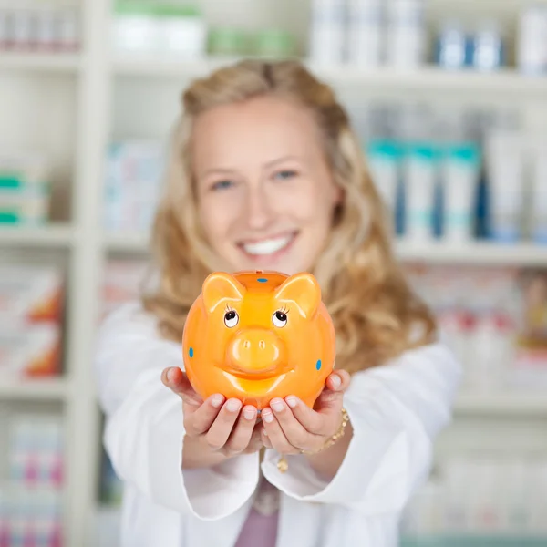 Farmacéutica joven Holding Piggybank —  Fotos de Stock