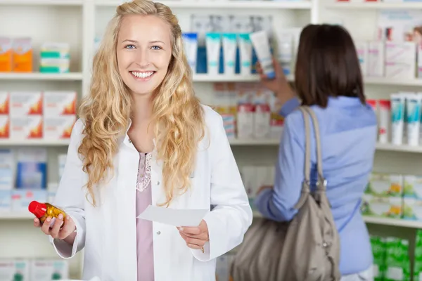 Farmacêutico sorridente com papel de prescrição — Fotografia de Stock