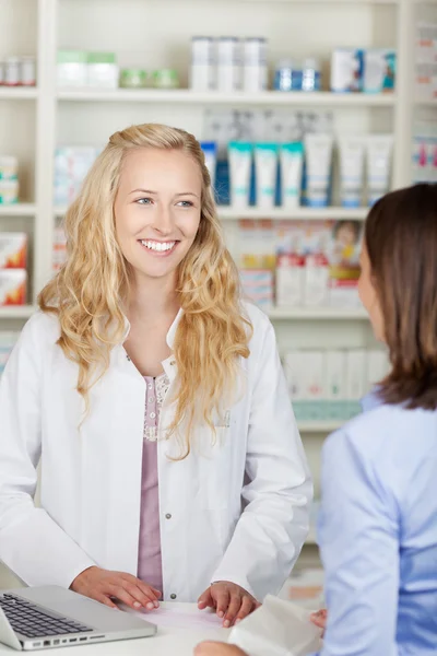 Farmacista guardando il cliente in farmacia — Foto Stock