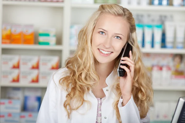 Vrouwelijke apotheker communiceren via draadloze telefoon — Stockfoto