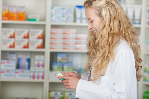 Vrouwelijke apotheker met geneeskunde van plank — Stockfoto