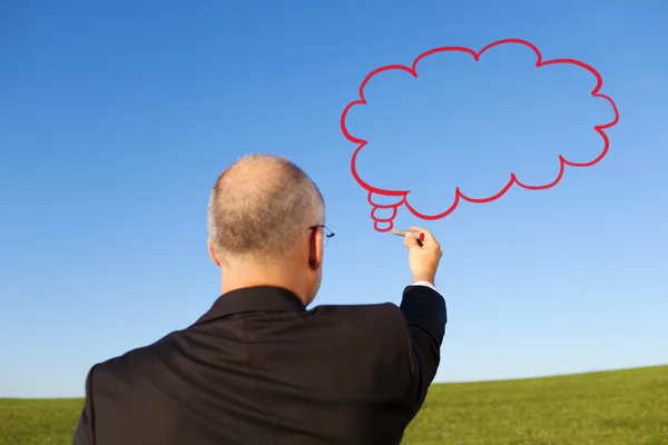 Бизнесмен рисует мысленный пузырь на небе — стоковое фото