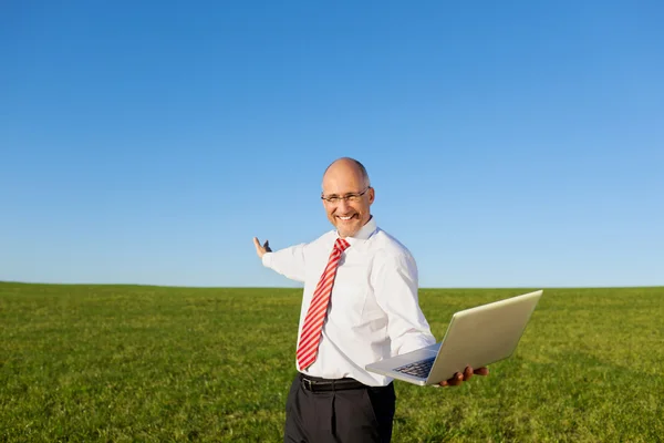 Opgewonden zakenman met armen gestrekt bedrijf laptop op fil — Stockfoto