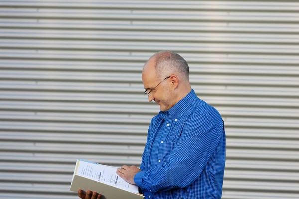 Empresário Lendo Livro Contra Obturador — Fotografia de Stock