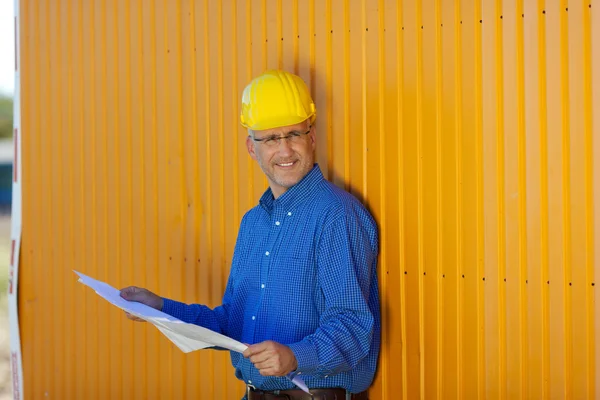 Architect dragen veiligheidshelm met blauw afdrukken — Stockfoto