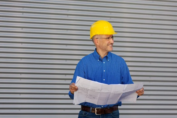 Architect Holding Blueprint While Looking Away Against Shutter — Stock Photo, Image