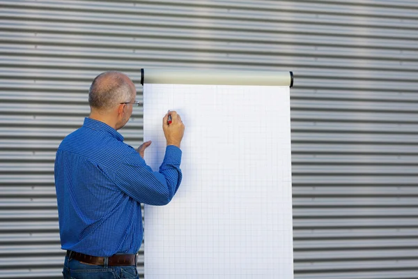 Mogna affärsman gör presentationen på blädderblock — Stockfoto