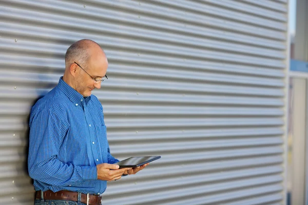 Podnikatel drží čtení na digitálním tabletu — Stock fotografie