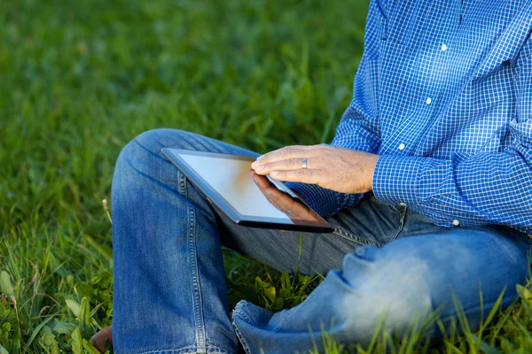 Buik van zakenman met behulp van digitale Tablet op gras — Stockfoto