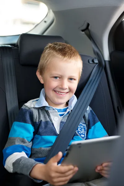 Jonge jongen zitten houden een tablet — Stockfoto