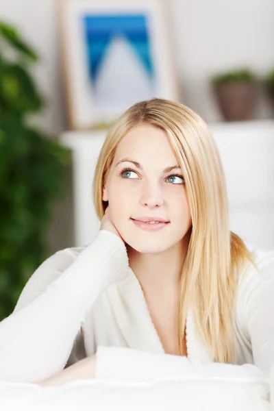 Jeune femme pensant tout en étant assis sur le canapé — Photo