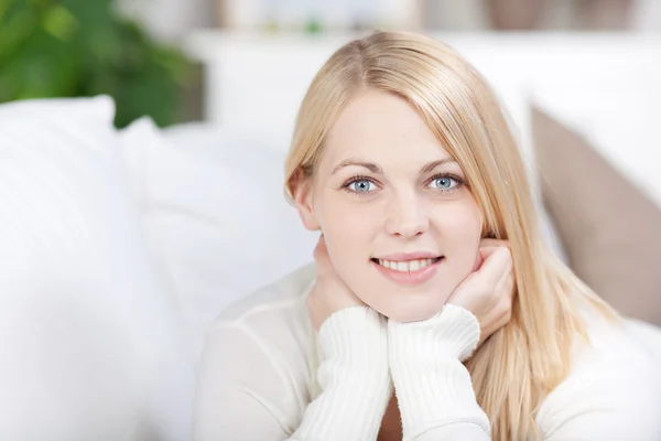 Joven mujer sonriendo mientras se acuesta en el sofá —  Fotos de Stock