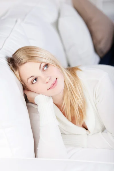 Jeune femme relaxante et souriante à la maison sur le canapé — Photo