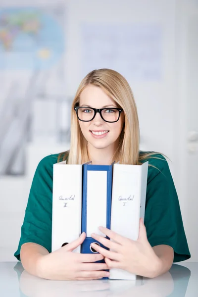 Empresaria con gafas mientras sostiene carpetas en el escritorio —  Fotos de Stock