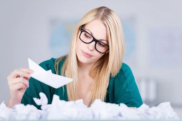 Zakenvrouw papier boot met paperballs op de voorgrond houden — Stockfoto