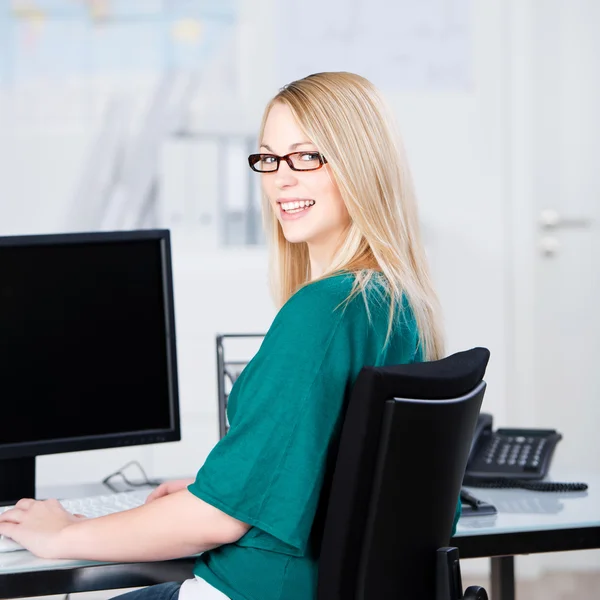 Bilgisayar başında oturan iş kadını gülümseyen — Stok fotoğraf