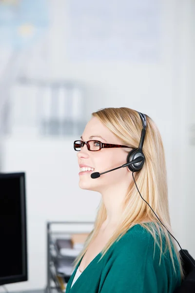 Ejecutivo de servicio al cliente usando auriculares mientras mira hacia otro lado —  Fotos de Stock