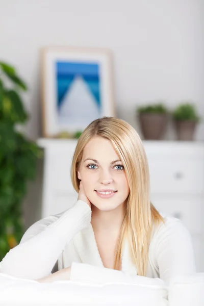Young Woman Smiling While Sitting On Sofa Royalty Free Stock Images