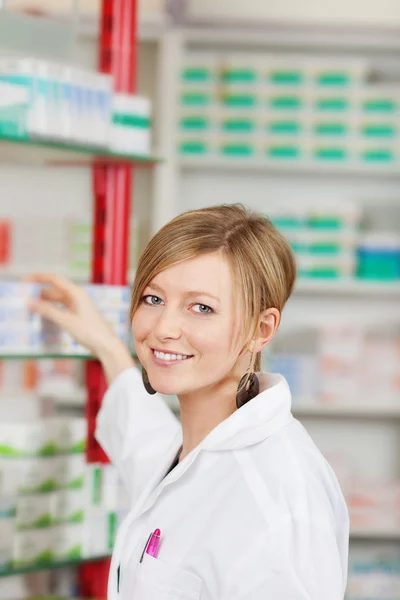 선반에서 의학을 선택 하는 여성 약사 — 스톡 사진