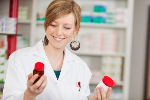 Vrouwelijke apotheker houden geneeskundeflessen — Stockfoto