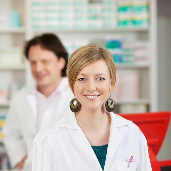 Farmacéutica femenina con compañera de trabajo en farmacia —  Fotos de Stock