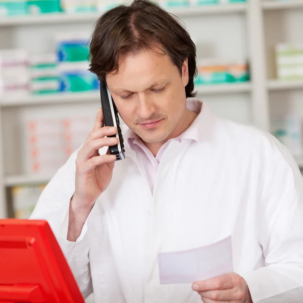 Pharmacist looking serious while on call — Stock Photo, Image