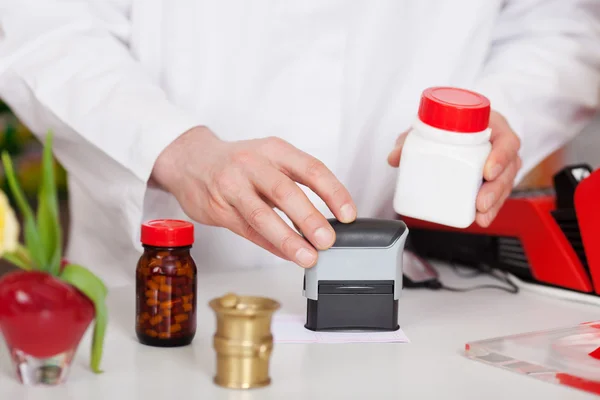 Factura de estampado del farmacéutico en el escritorio de farmacia —  Fotos de Stock