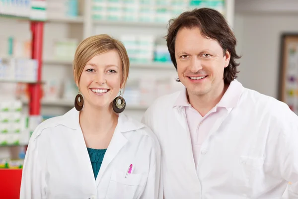 Kvinnliga farmaceut med medarbetare i apotek — Stockfoto