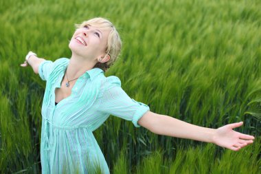 Pretty woman rejoicing in a green field clipart