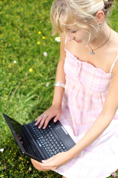 Женщина работает на своем ноутбуке в природе — стоковое фото