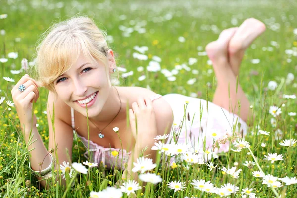 Beautiful woman relaxing amongst daisies — Stock Photo, Image