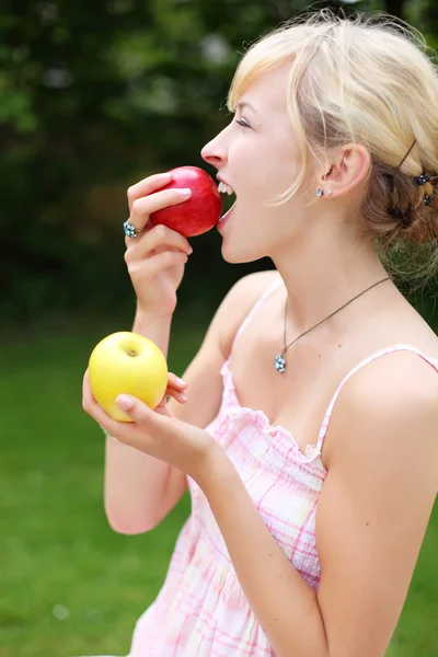 Mulher loira comendo uma maçã vermelha fresca — Fotografia de Stock