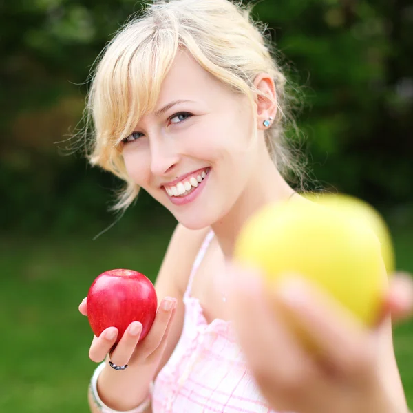 Schöne Frau bietet einen Apfel an — Stockfoto