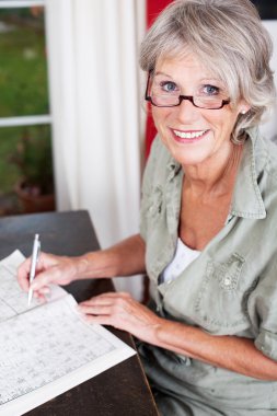 Older woman wearing glasses working clipart