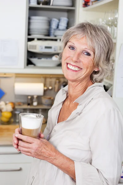 Elderly woman enjoying a cup of cappuccino — Stock Photo, Image