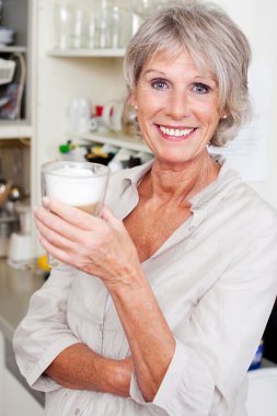 Modern senior woman in her kitchen clipart
