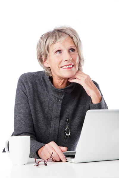 Thoughtful senior woman with a laptop — Stock Photo, Image