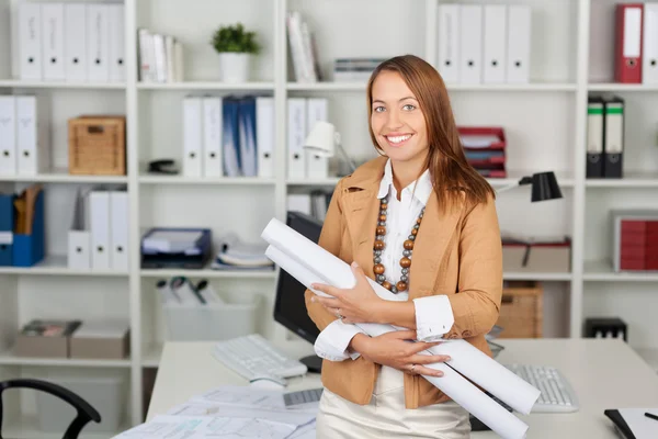 Zakenvrouw blauwdrukken houden op Bureau — Stockfoto