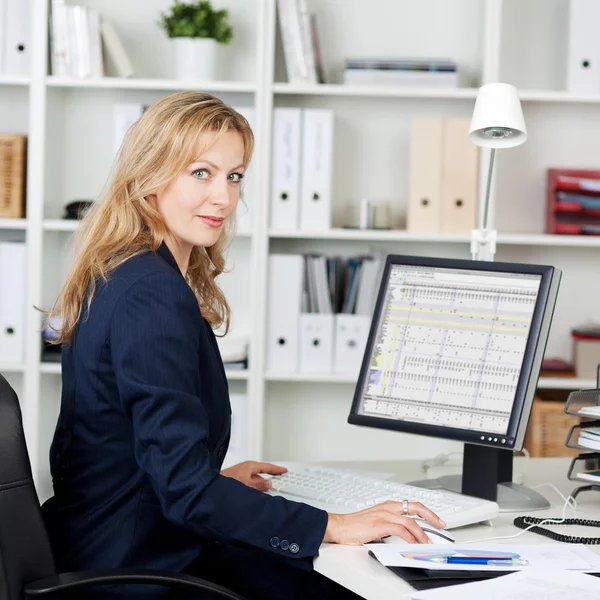 Empresaria adulta usando computadora en el escritorio —  Fotos de Stock