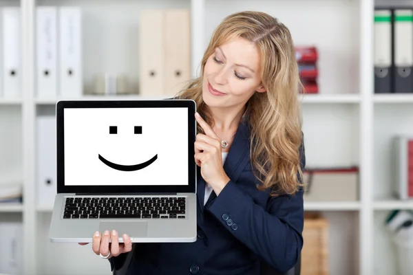 Επιχειρηματίας, εμφανίζοντας το χαμογελαστό πρόσωπο στην οθόνη του φορητού υπολογιστή — Φωτογραφία Αρχείου