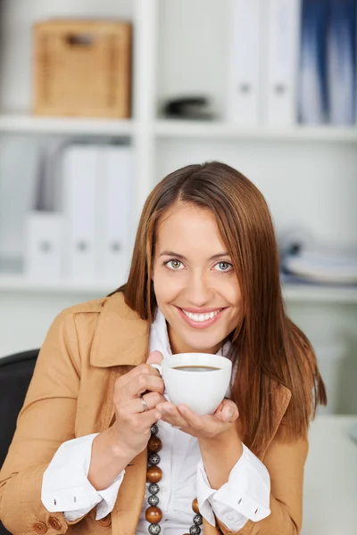 Affidabile donna d'affari che tiene una tazza di caffè alla scrivania — Foto Stock