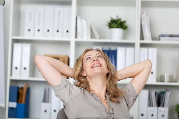 Geschäftsfrau entspannt sich am Schreibtisch — Stockfoto