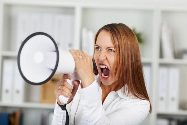 Разочарованная деловая женщина, кричащая через мегафон — стоковое фото