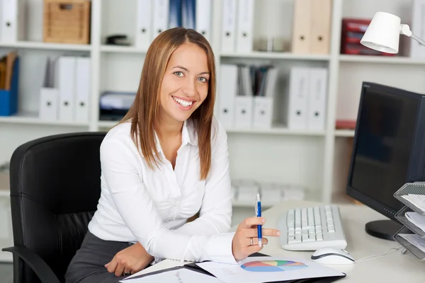 Zakenvrouw bedrijf pen op Bureau — Stockfoto