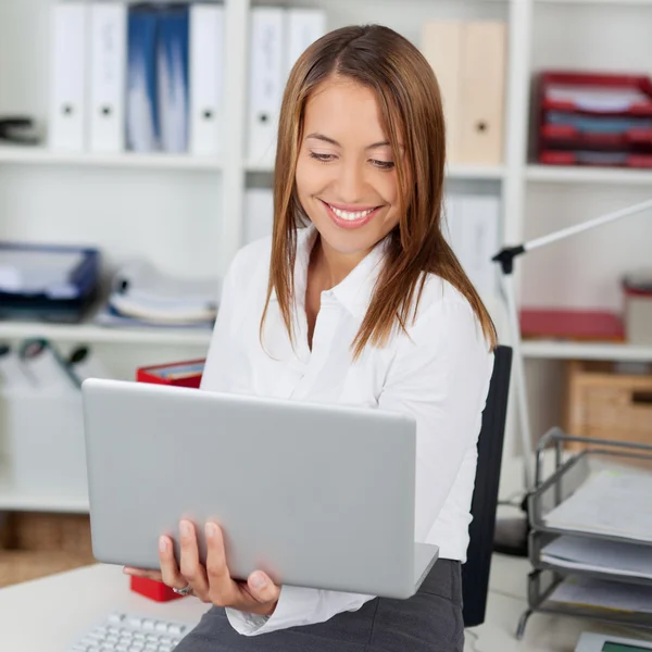 Affärskvinna anläggning laptop i office — Stockfoto