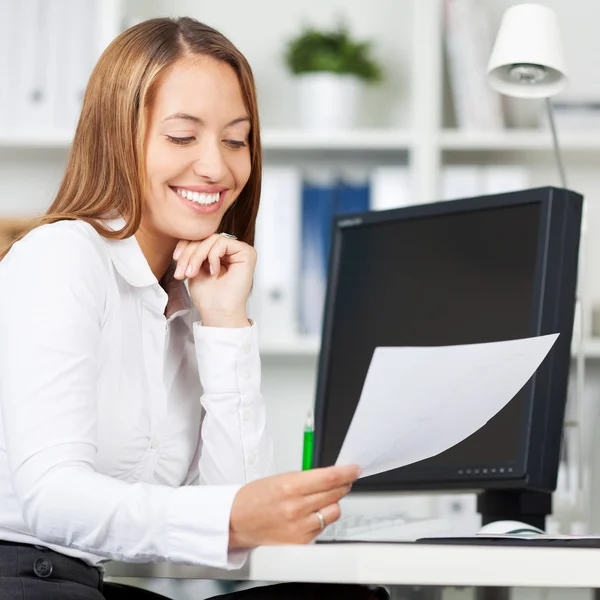 Zakenvrouw kijken naar document in office — Stockfoto