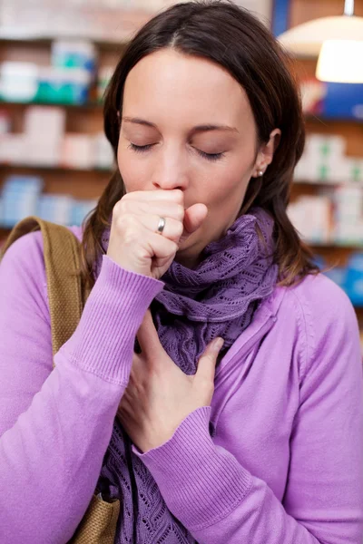 Sjuk kvinna hosta i farmaci — Stockfoto